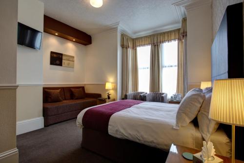 a hotel room with a bed and a couch at Park View Guest House in Bridlington