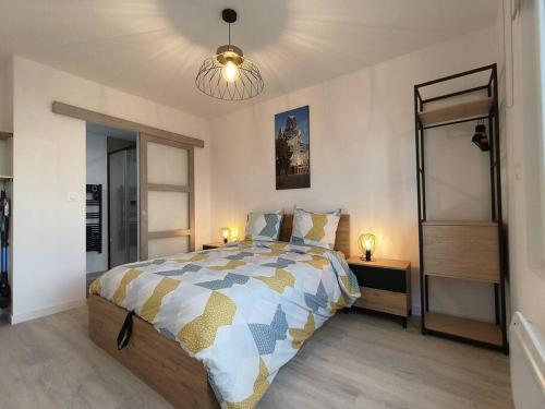una camera con un grande letto e un lampadario a braccio di Stalingrad Arles Centre a Arles