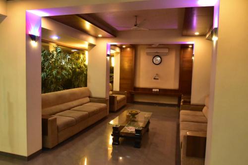 a living room with a couch and a table at Hotel Dhantara in Shirdi