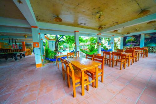 a dining room with wooden tables and chairs at Phong Nha Dawn Home in Phong Nha