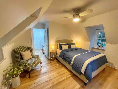 1 dormitorio con 1 cama y 1 silla en Blake House Historic Estate with Private Inn en Centreville