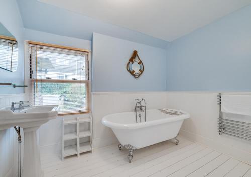 uma casa de banho branca com uma banheira e um lavatório em Karrys em Lynmouth