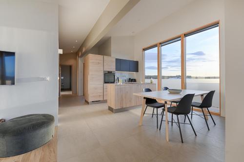 a kitchen and dining room with a table and chairs at Kerbyggd: Luxury house and cottage in golden circle in Selfoss