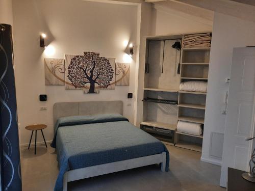 la suite oasi di relax e comfort IUN R1091 في أوريستانو: غرفة نوم بسرير وشجر على الحائط