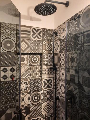 a bathroom with a shower with tiles on the wall at la suite oasi di relax e comfort IUN R1091 in Oristano