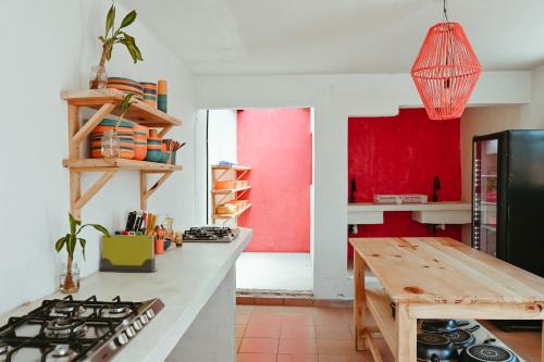 a kitchen with a stove and a red wall at Maka Hostel in Oaxaca City