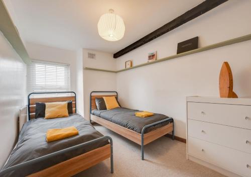 a bedroom with two beds and a dresser in it at Kimblewick in Braunton