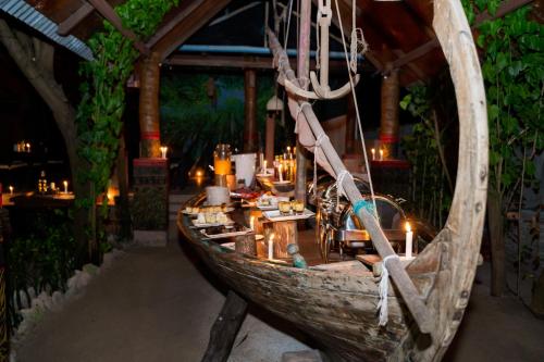 a wooden boat with a table in a restaurant at Salt Villa Ukulhas in Ukulhas