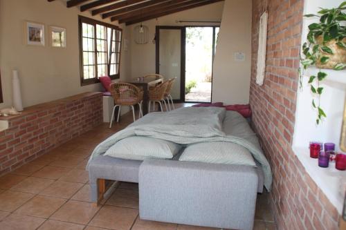 a bed in a room with a brick wall at Casa Pura Vida - Malaga - Andalusië in Colmenar