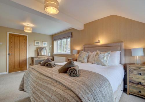 a bedroom with a large bed with towels on it at Keepers Cottage Lynton in Barbrook