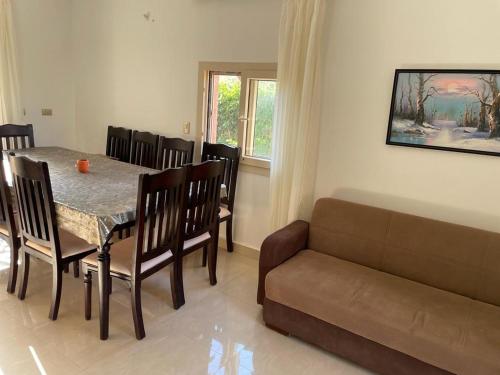 a dining room with a table and a couch at Seaview luxury Villa in Ras El Hekhma - North Coast in Ras Elhekma