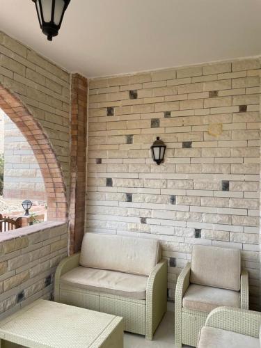 a patio with a couch and chairs and a table at Seaview luxury Villa in Ras El Hekhma - North Coast in Ras Elhekma