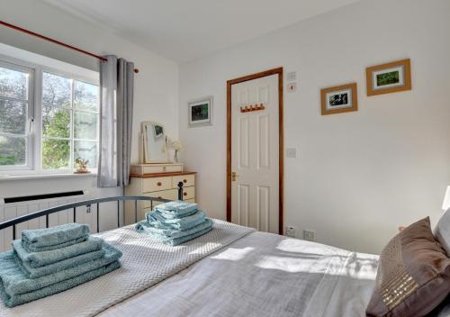 a bedroom with a bed with blue towels on it at Kingfisher Cottage in East Down