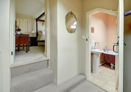 a bathroom with a tub and a sink and a bathroom with a mirror at Laurel Cottage in Parracombe