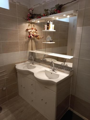 a bathroom with two sinks and a mirror at Au Soleil Couchant in Sarlat-la-Canéda