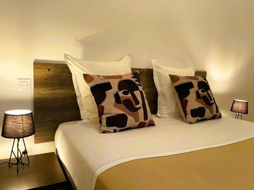 a bed with brown and white pillows on it at Pavillon de l’Étang in Châteauneuf-du-Rhône