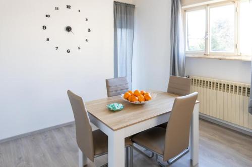 a dining room table with chairs and a bowl of oranges on it at Elite Home in Monfalcone