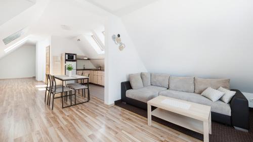 a living room with a couch and a table at Apartamenty Sun & Snow Pardałówka in Zakopane