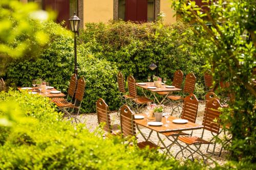 a group of tables and chairs in a garden at Hotel München City Center affiliated by Meliá in Munich