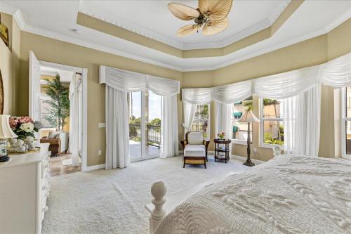 a bedroom with a white bed with a ceiling fan at Ocean Vue in Siesta Key