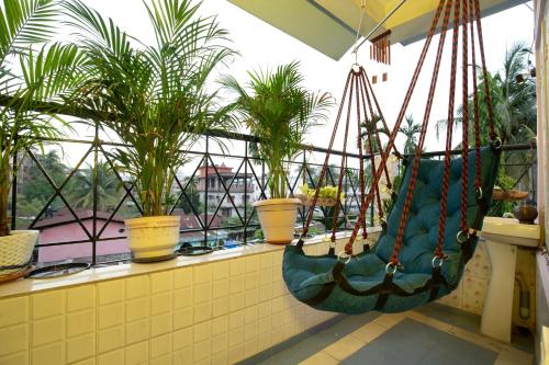 a balcony with two swings and potted plants at BimBan's- A cozy little place in Guwahati