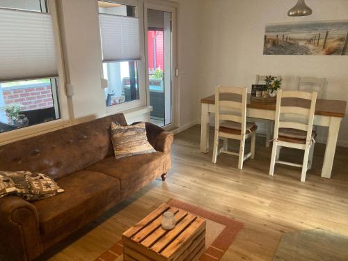 a living room with a couch and a table and chairs at Ferienhaus Scandia am See in Warnitz