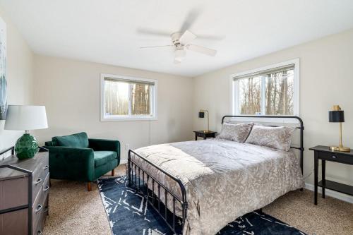 - une chambre avec un lit et une chaise verte dans l'établissement Modern Chalet Cabin w Hot Tub, Fire Pit, Huge Deck, à Inwood