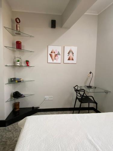 a bedroom with a bed and shelves on the wall at Apart Hotel Seg Total Lofts Encantadores in Mogi-Guaçu