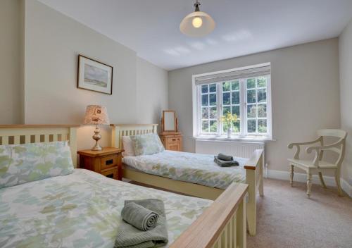 a bedroom with two beds and a window at Mariners in Barbrook