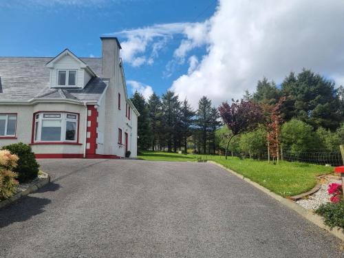 a white house with a driveway at Kelmin House in Letterkenny