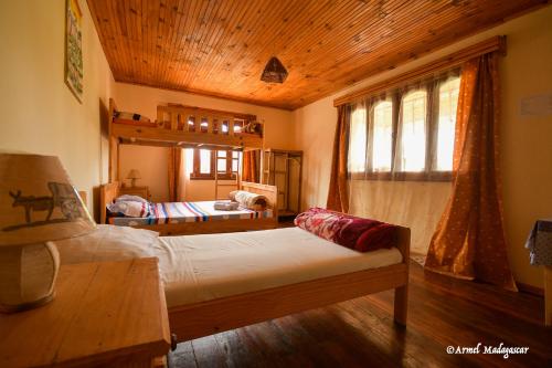 a bedroom with a bed and a wooden ceiling at An-tsaha Chambre d'hôtes in Fianarantsoa