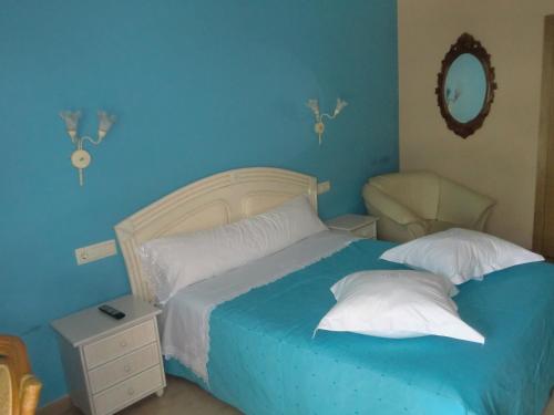 a blue bedroom with a bed with two pillows at Hotel Gasaqui in Ayelo de Malferit