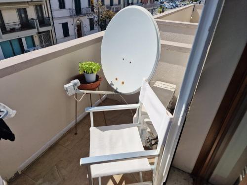 a white chair and a mirror on a balcony at Relax al Mare in Viareggio