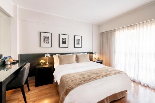 a bedroom with a large bed and a desk at Principado Downtown in Buenos Aires