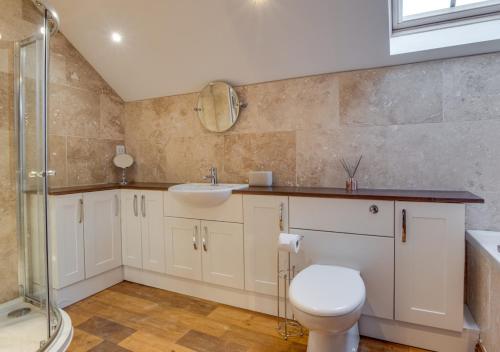 a bathroom with a toilet and a sink and a shower at Mill Barn in Bishops Nympton