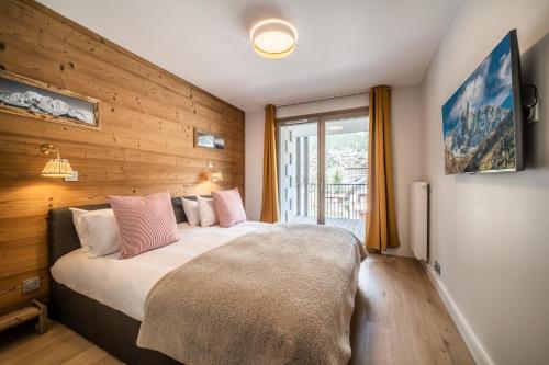 - une chambre avec un lit doté d'oreillers roses et d'une fenêtre dans l'établissement Kabano Chamonix - BY EMERALD STAY, à Chamonix-Mont-Blanc