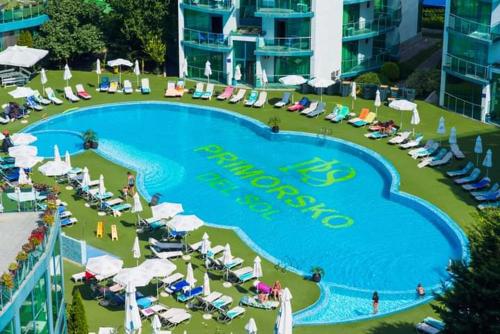 a large swimming pool with chairs and umbrellas at Двустаен апартамент в Приморско in Primorsko
