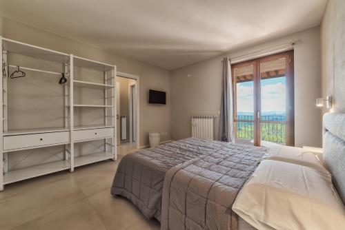 a bedroom with a bed and a large window at Bellaria Rooms in Montalcino