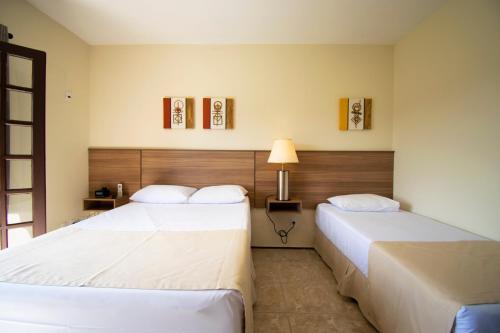 Hotel Dona Paschoalina في سوكورو: غرفه فندقيه سريرين ومصباح