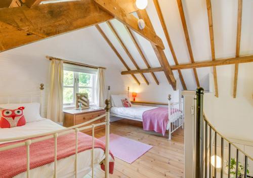 a bedroom with two beds and a window at Mill Cottage in Parracombe