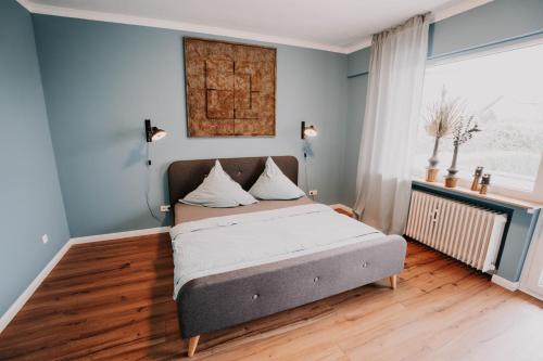 1 dormitorio con 1 cama en una habitación con paredes azules en SOONWALD Apartment mit Garten & Hot Tube, en Stromberg