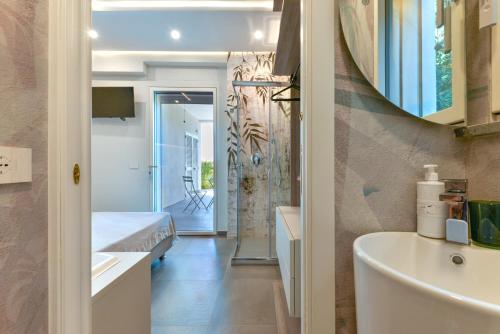 a bathroom with a bed and a sink and a mirror at Villa Serena vista mare in Lacona