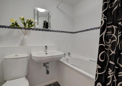 a bathroom with a toilet and a sink and a tub at Dune View Instow in Instow