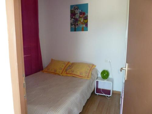 a small bedroom with a bed and a picture on the wall at Iris Caromb in Caromb