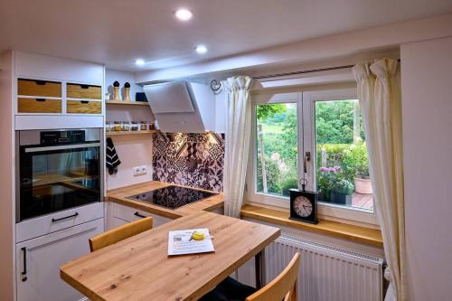 eine Küche mit einem Holztisch und einem Fenster in der Unterkunft Chic & Blick Die Ferienwohnung in Ebermannstadt