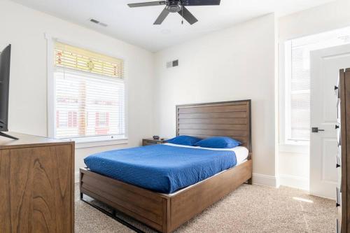 Entire Home in Newport في نيوبورت: غرفة نوم مع سرير مع أوراق زرقاء ومروحة سقف