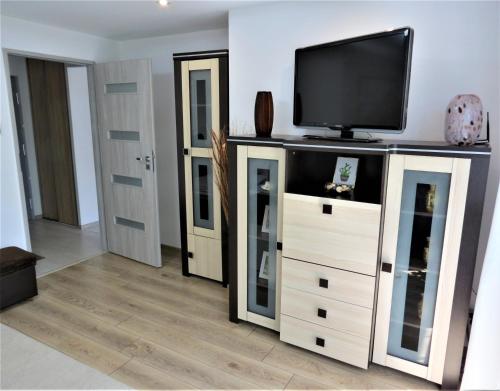 ビャワ・ボドラスカにあるApartament KOPERNIK Xのリビングルーム(エンターテイメントセンター内の薄型テレビ付)