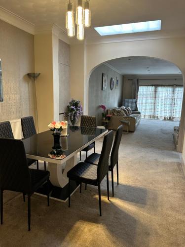 a living room with a dining room table and chairs at Amazing 4 Bedrooms family home with free parking in Romford