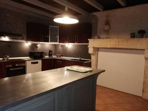 - une cuisine avec un grand comptoir dans une pièce dans l'établissement Maison charentaise à la campagne, à Bécheresse