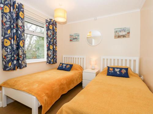 two beds in a room with a window at 8 Royal Chalet Park in Norwich
